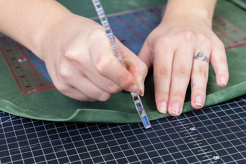 folding a double hem with the canvas patterning ruler